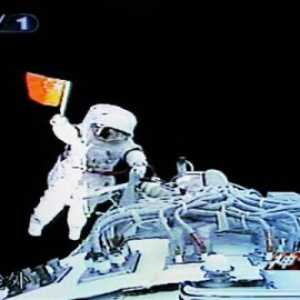 Image: Zhai Zhigang waves a small Chinese flag shortly after climbing out of the Shenzhou VII spacecraft